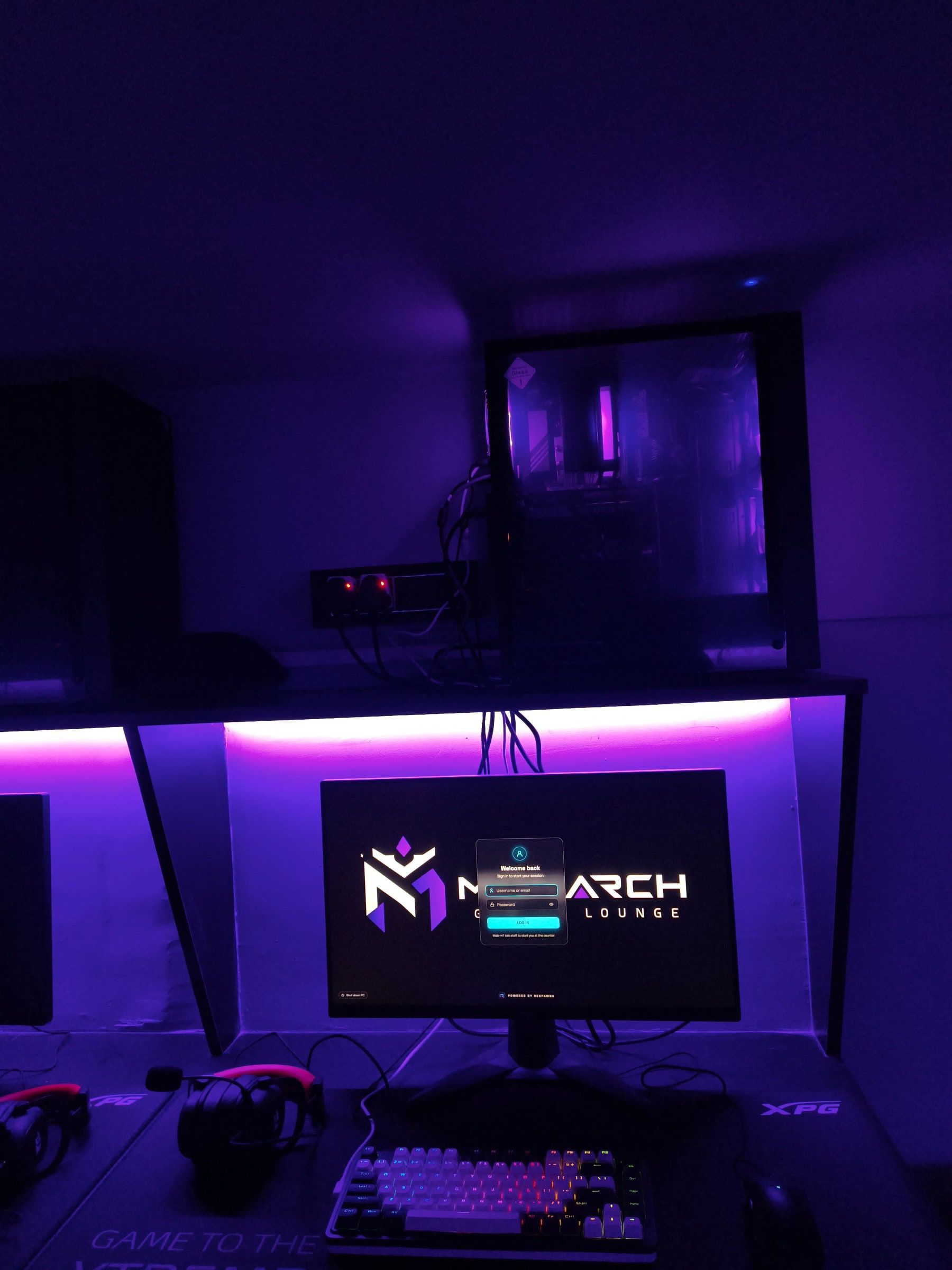A Monarch PC station with the tower on the shelf above, a purple light strip and the monitor below.